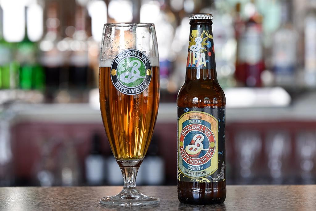 Kotka, Finland - May 5, 2021: A glass and a bottle of Brooklyn Defender IPA of Brooklyn Brewery